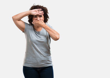 眯着眼睛烦恼着太亮的灯,黑色的背景眯着眼睛的女人与奇怪的表情孤