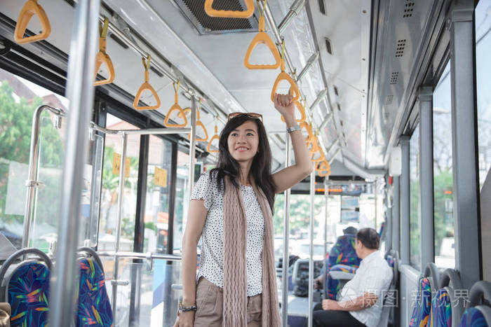 站在公交车上的亚洲女孩