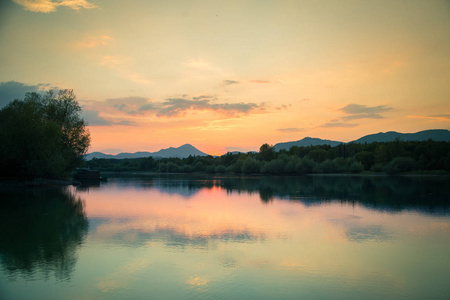 一个美丽的彩色日落景观与湖山和森林。 夏天山湖上的自然傍晚景色。 斯洛伐克欧洲的塔特拉山。