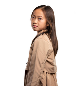 穿米色战衣的中国小女孩站在白色背景下
