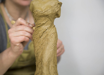 雕塑家艺术家用粘土制作半身雕塑。 雕塑家在工作。