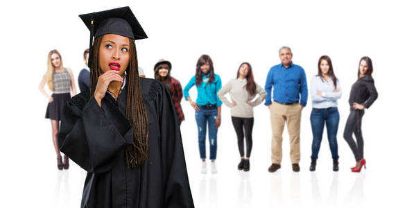 年轻的毕业黑人妇女戴着辫子，怀疑和困惑地想着一个想法或担心什么