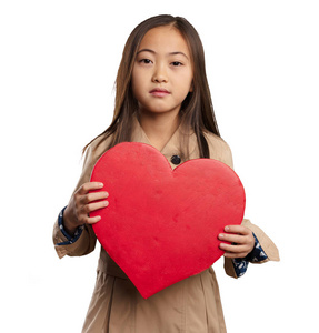 穿着米色战衣的中国小女孩，她的心脏形状与白色背景隔离