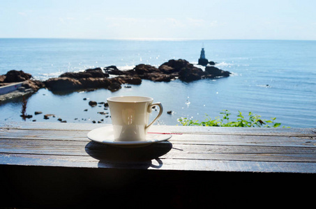 提供海景的桌子上的咖啡杯。度假期间的夏季早晨概念