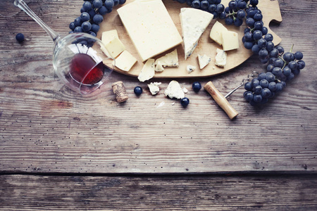 木制背景下的葡萄奶酪和葡萄酒的美味成分