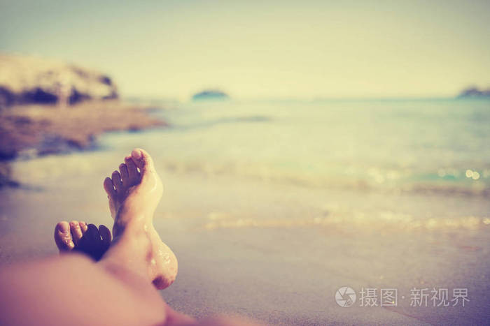 在沙滩上裸露的男性赤脚对抗海水