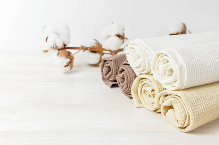 五颜六色的干净毛巾与一支棉花在一个轻木背景与复制空间。 棉华夫饼毛巾纺织品的质地。 厨房或水疗概念的毛巾。 孤立的物体