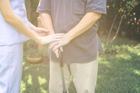 s hand in outdoor garden. Senior care, care taker and senior ret