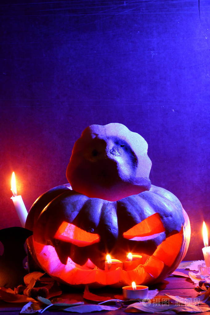 万圣节在深蓝色的灯光下发光的南瓜蝙蝠万圣节南瓜头杰克灯笼在木制
