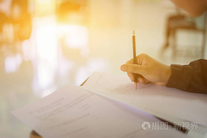 男性手拿笔,抽象背景模糊的书写检查