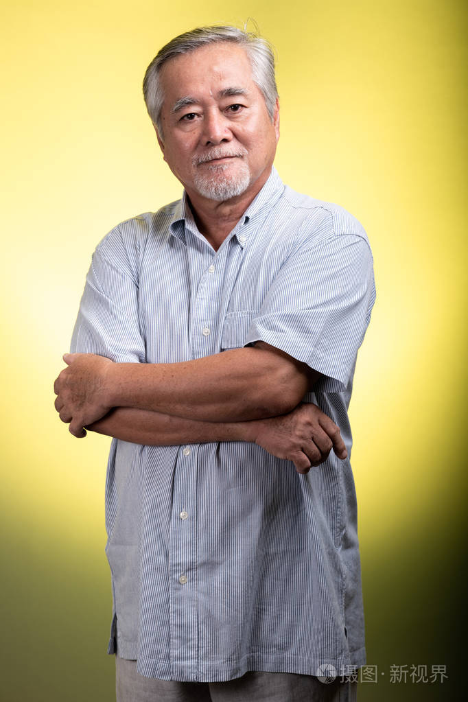 戴着白胡子的亚洲老人站在镜头前微笑. 高级生活方式概念.