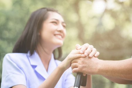 s hand in outdoor garden sitting on bench. Senior care, care tak