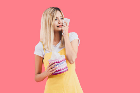 伤心的年轻女人,带着纸巾盒,哭着擦着粉红色的眼泪照片