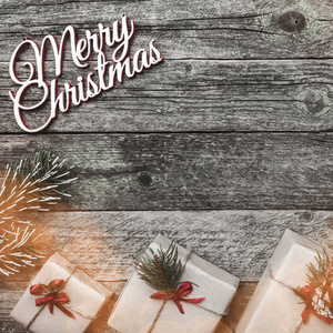 木制方形背景。 圣诞快乐铭文空间杉树枝和礼物。 上面的风景。 物品及冬季礼品