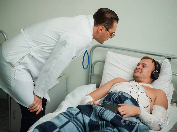 男医生在医院和一位年轻病人谈话