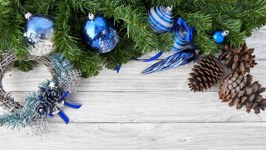圣诞树上的圣诞装饰品在古老的白橡木地板上，空白的空间模仿太阳的光。 假期的装饰想法。