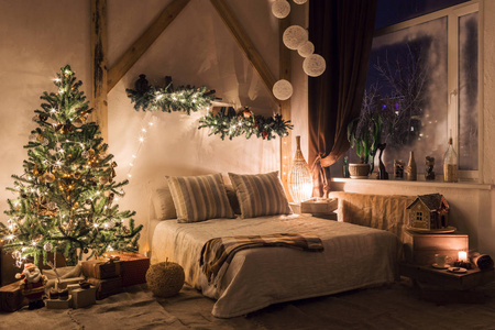 客厅里温暖舒适的夜晚。沙发床在圣诞节室内。概念新年和假日