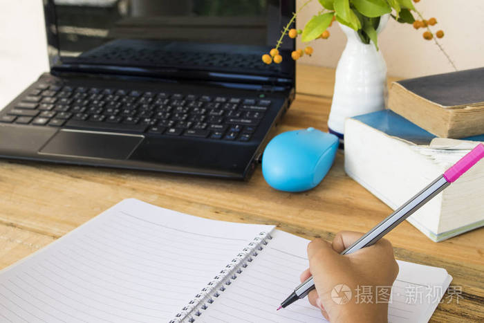 学生女孩写和读一本书字典英语学习和电脑笔记本在桌上