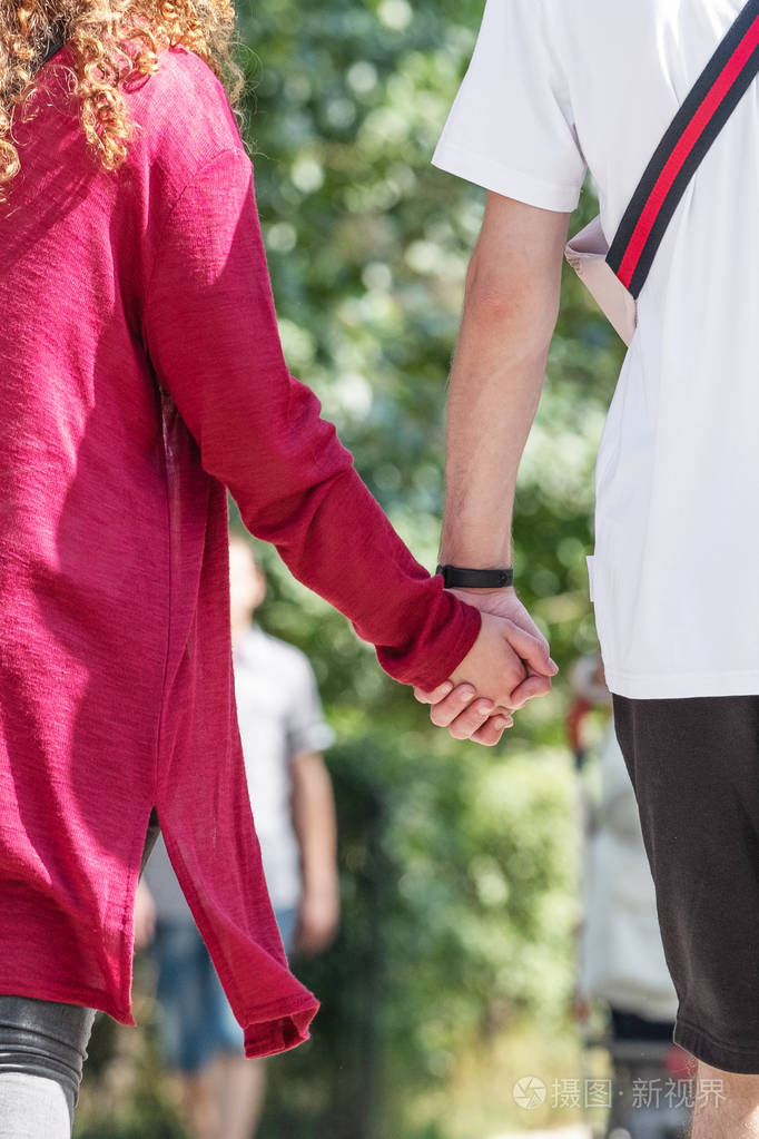 一个男孩和一个女孩手牵手走着