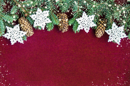 圣诞装饰背景与白色钩针雪花和冷杉锥附近新鲜的自然枝条圣诞树云杉在红色天鹅绒背景。卡的概念。上景。平躺着。复制空间。
