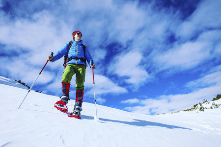 雪鞋步行者在粉雪中奔跑，有美丽的日出光。 户外冬季活动和健康生活方式