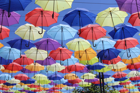 五颜六色的雨伞，城市街道装饰。 挂着五颜六色的雨伞