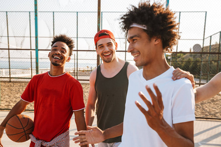 白种人和美国男人在夏天阳光明媚的日子里在户外操场上打篮球的形象
