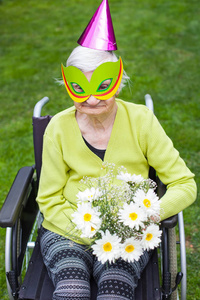 坐在轮椅上的残疾老年妇女收到生日花束