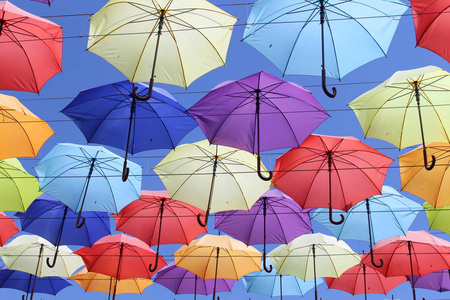 五颜六色的雨伞，城市街道装饰。 挂着五颜六色的雨伞