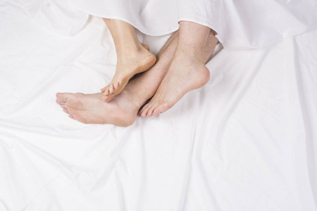 在一张床的四个脚的关闭两个性别符号维纳斯从黄色背景的粉红色纸上剪