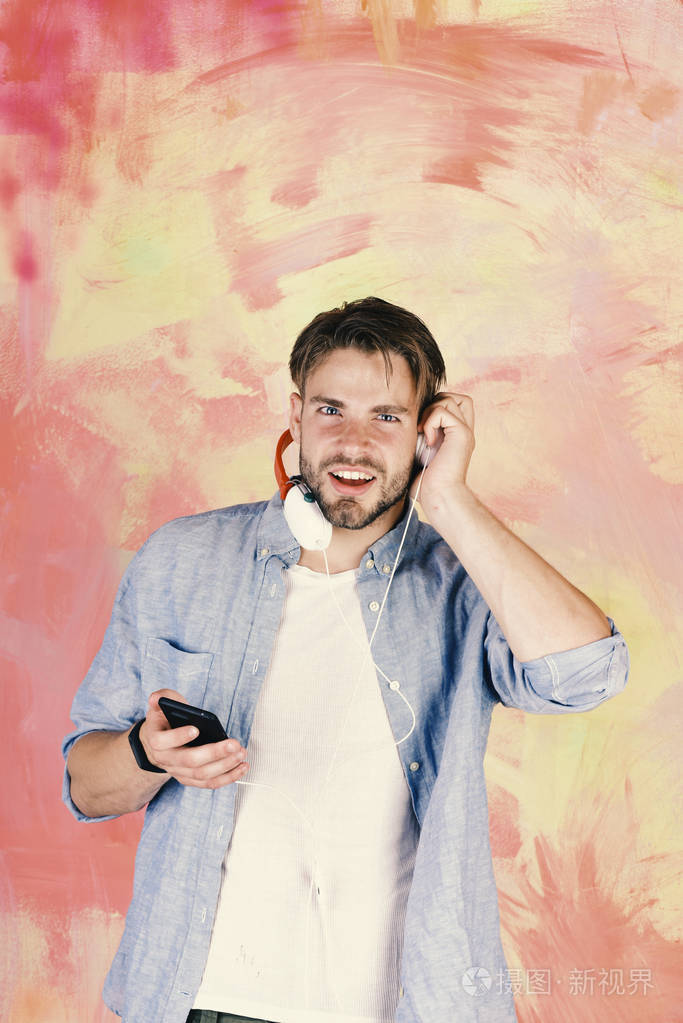 欢快的青少年 dj 通过耳机收听歌曲.戴着耳机的美国英俊的大胡子男人.