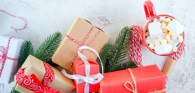 圣诞装饰背景与冷杉树枝锥红和黑色圣诞礼物与丝带在白色背景。 卡假日概念。 复制空间顶部视图。