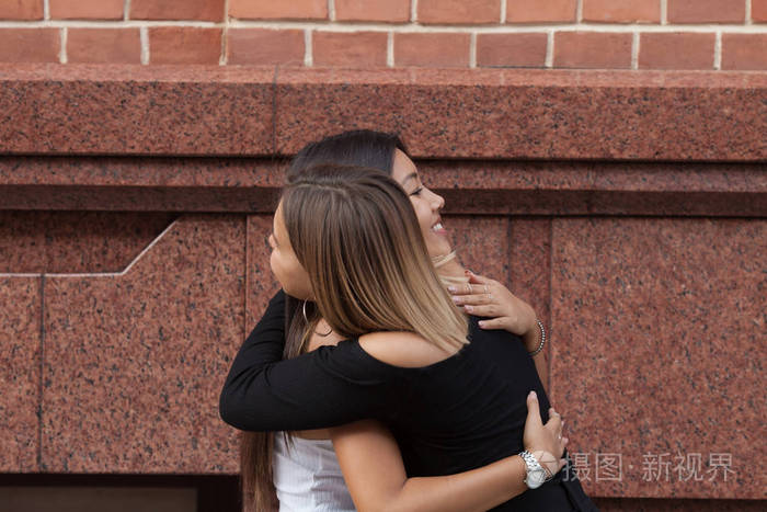 两个朋友在街上拥抱的快乐相遇