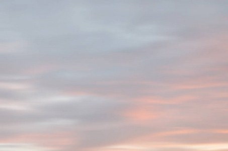 夕阳天空的模糊镜头。 抽象的自然背景与云的淡色调。