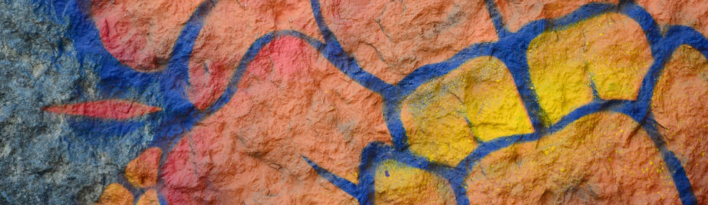 涂鸦图纸的碎片。 在街道艺术文化的风格中，用油漆污渍装饰的旧墙。 橙色的花。