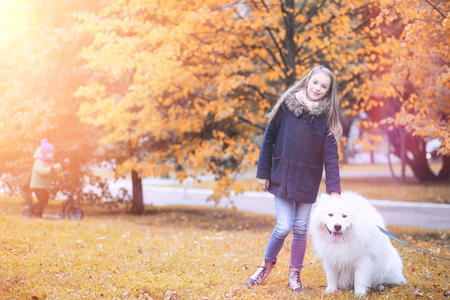 可爱的女孩散步与一条美丽的狗