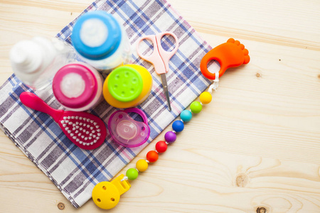 s shoes and toys on white wooden boards background. Newborn. Top