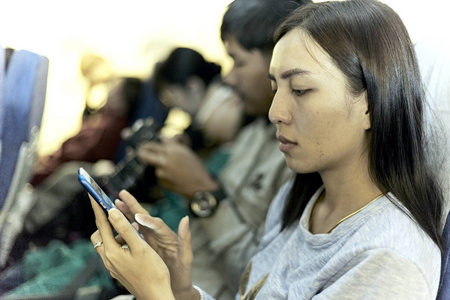 女人手里拿着智能手机女人在家打电话找家人在飞机上度假的想法关掉智能手机