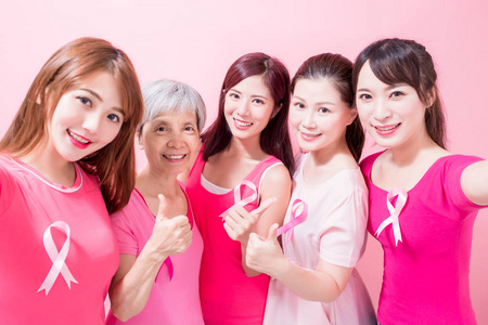 女人快乐地自拍。 粉红色背景下的乳腺癌预防