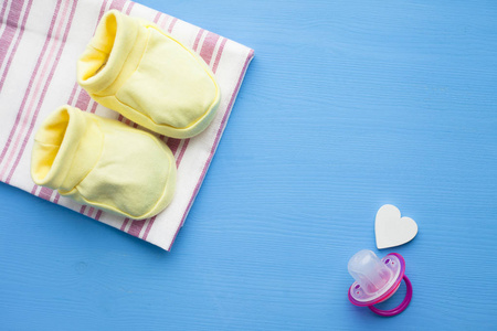 s shoes and toys on blue background. Newborn. Top view