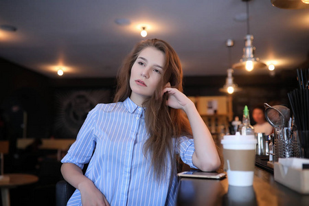 有咖啡的女孩。年轻漂亮的女孩坐在咖啡馆里