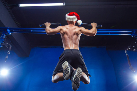 节日和庆典, 新年, 圣诞节, 体育, 健美, 健康的生活方式肌肉英俊的圣诞老人。运动员肌肉健身男性模型在健身房水平杆上的