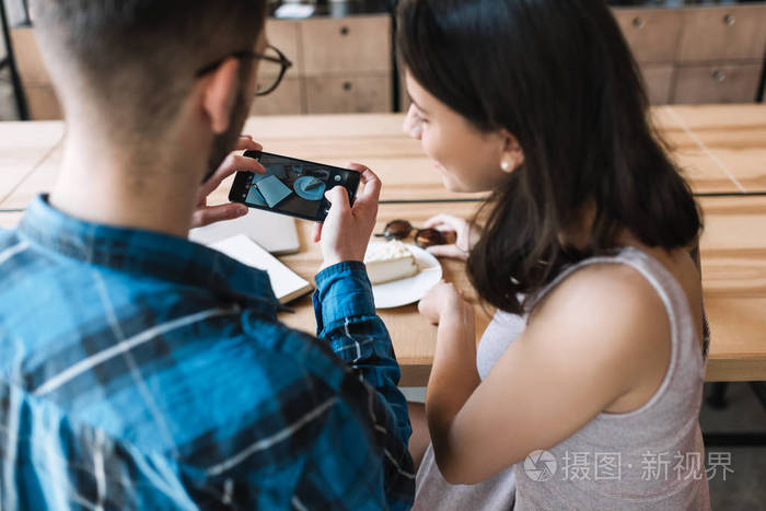 美丽的白种人女人和她的博客朋友一起交流,持有现代智能手机设备.