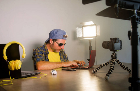 年轻有魅力的科技极客与笔记本电脑联网,为互联网社交媒体录制视频