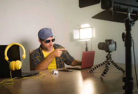 年轻有魅力的科技极客与笔记本电脑联网,为互联网社交媒体录制视频