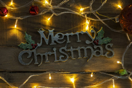 木制桌子上的圣诞彩灯装饰着圣诞快乐的文字