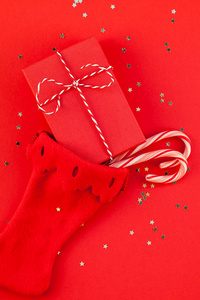创意新年圣诞礼物，包裹丝带，平躺，顶部查看圣诞节2019年假日庆祝手工礼品盒，诺埃尔袜子，红纸背景，共空间。 模板贺卡文字设计