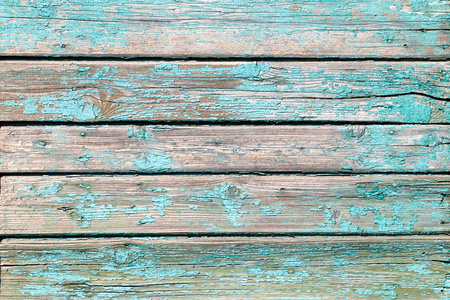 一种古老的木制背景，有干燥的剥落油漆和绿色和蓝色的大裂缝。