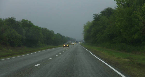 白天在雾蒙蒙的道路上行驶汽车的公路景观