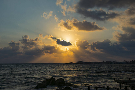 在岩石海滩中海水中日落的景观图片